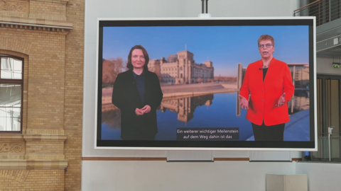 Sehr großer hängender Monitor Sehr großer hängender Monitor. Ein Video mit Simone Miesner und Erdmuthe Meyer zu Bexten wird gezeigt.
