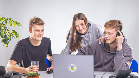 Drei Personen aus dem Azubi-Team schauen gemeinsame auf einen Laptop