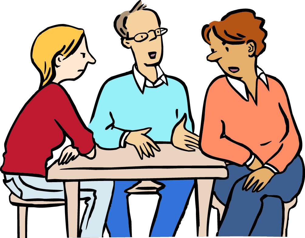 Drei Personen sitzen an einem Tisch und sprechen mit einander.